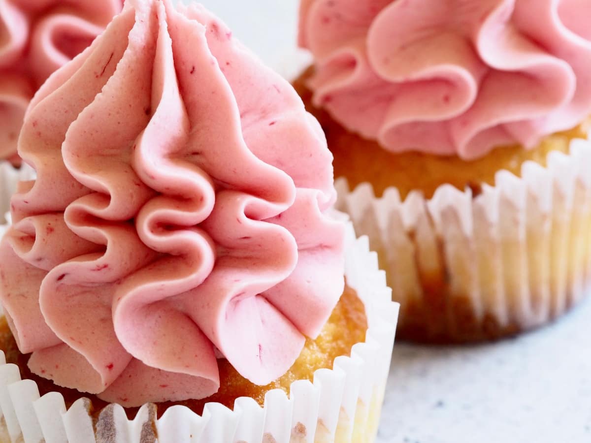 Cupcakes finished with softly piped pink buttercream swirls