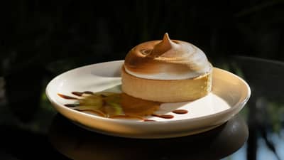 A torched dome of light chiboust cream on a plate