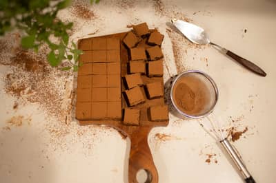 A mound of dark cocoa powder with chocolate truffles