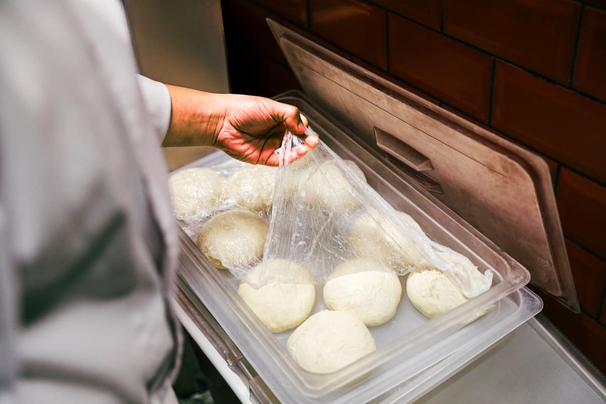 Portioned dough in containers headed for a slow, cold rise in the fridge