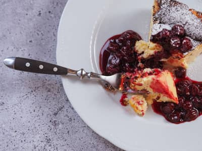 A dessert served with glossy berry compote spooned over the top