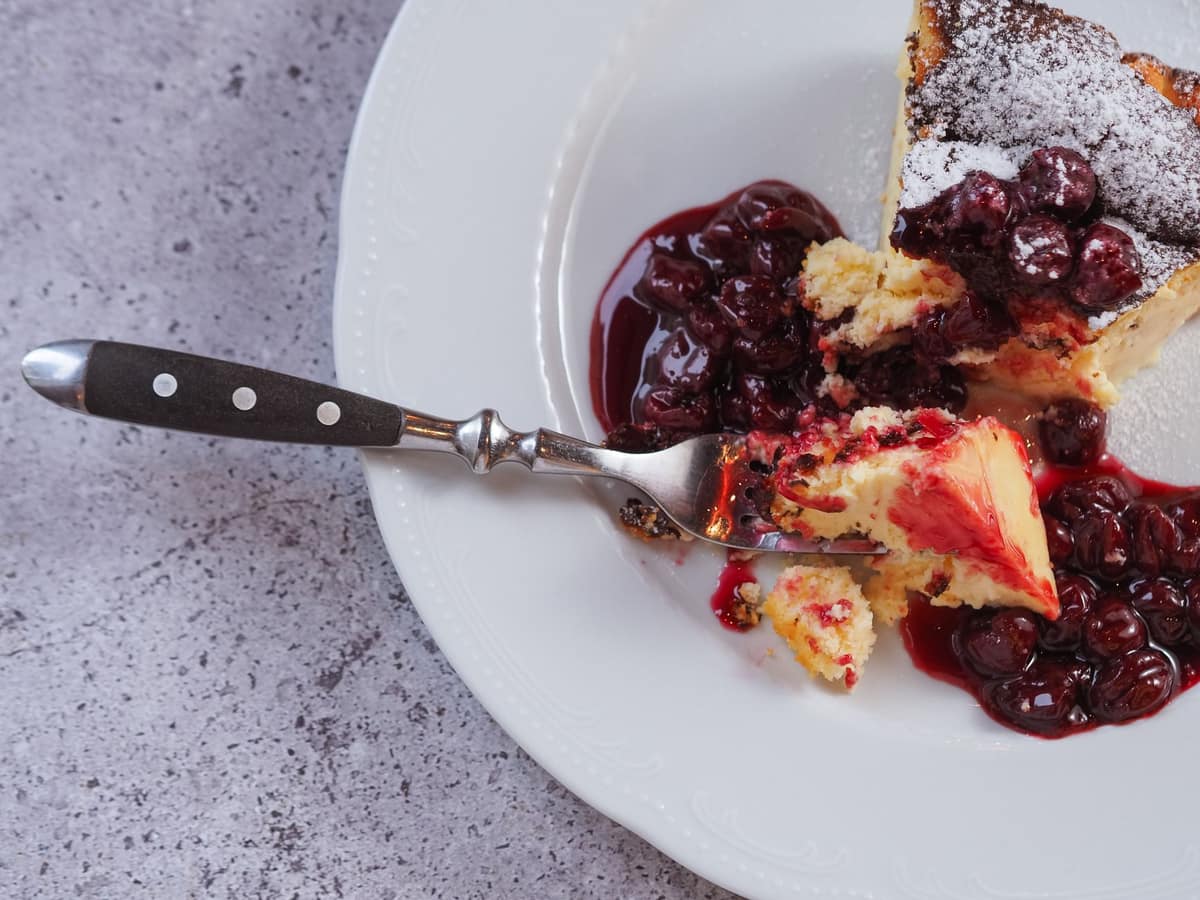 A dessert served with glossy berry compote spooned over the top