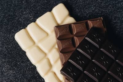 Bars of white, milk and dark couverture chocolate stacked together