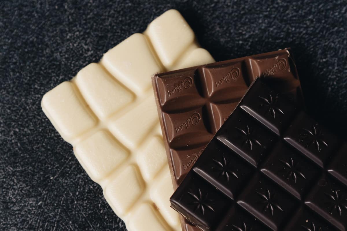 Bars of white, milk and dark couverture chocolate stacked together