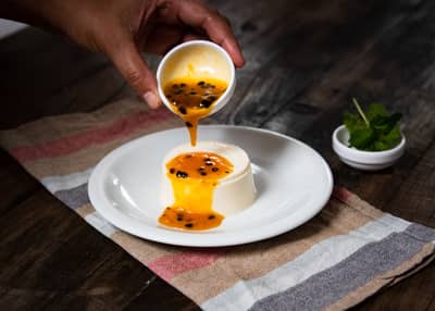 Silky vanilla custard sauce pouring from a spoon