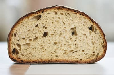 A slice of sourdough showing an open, airy crumb