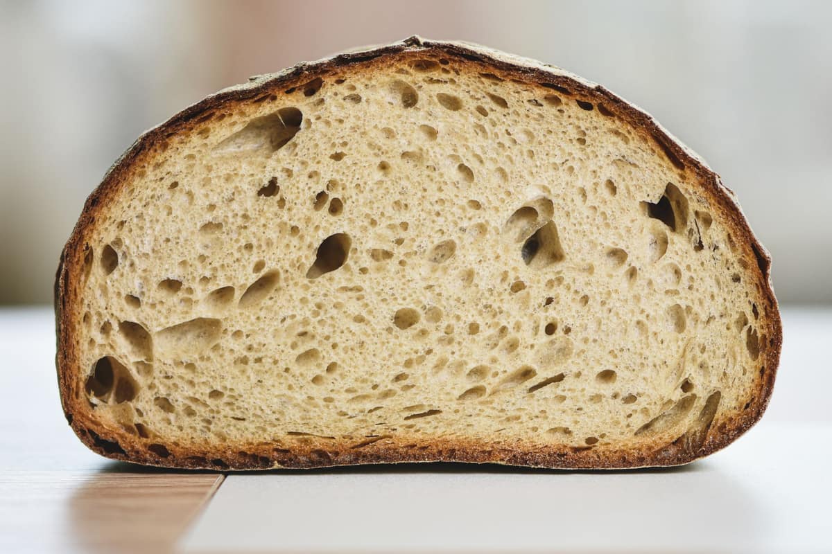 A slice of sourdough showing an open, airy crumb