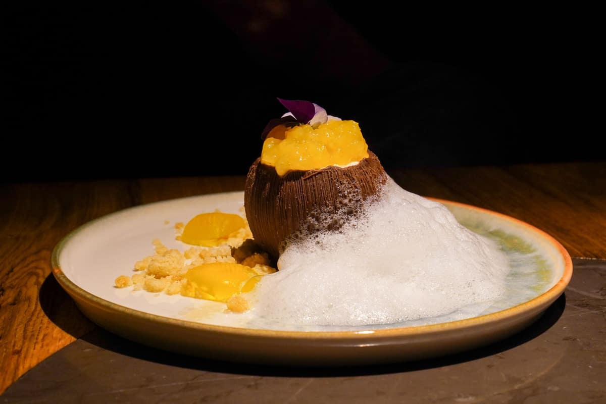 A plated dessert finished with a light culinary foam