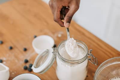 A spoonful being taken from a jar of active sourdough starter