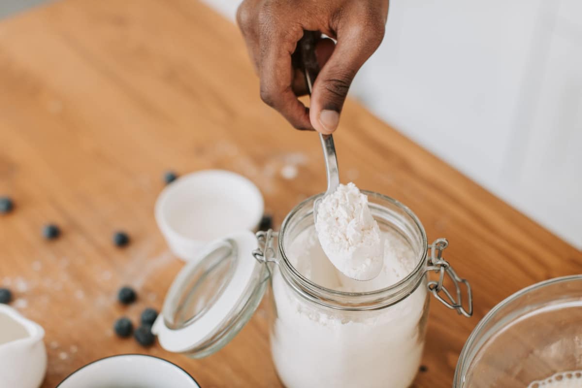 A spoonful being taken from a jar of active sourdough starter