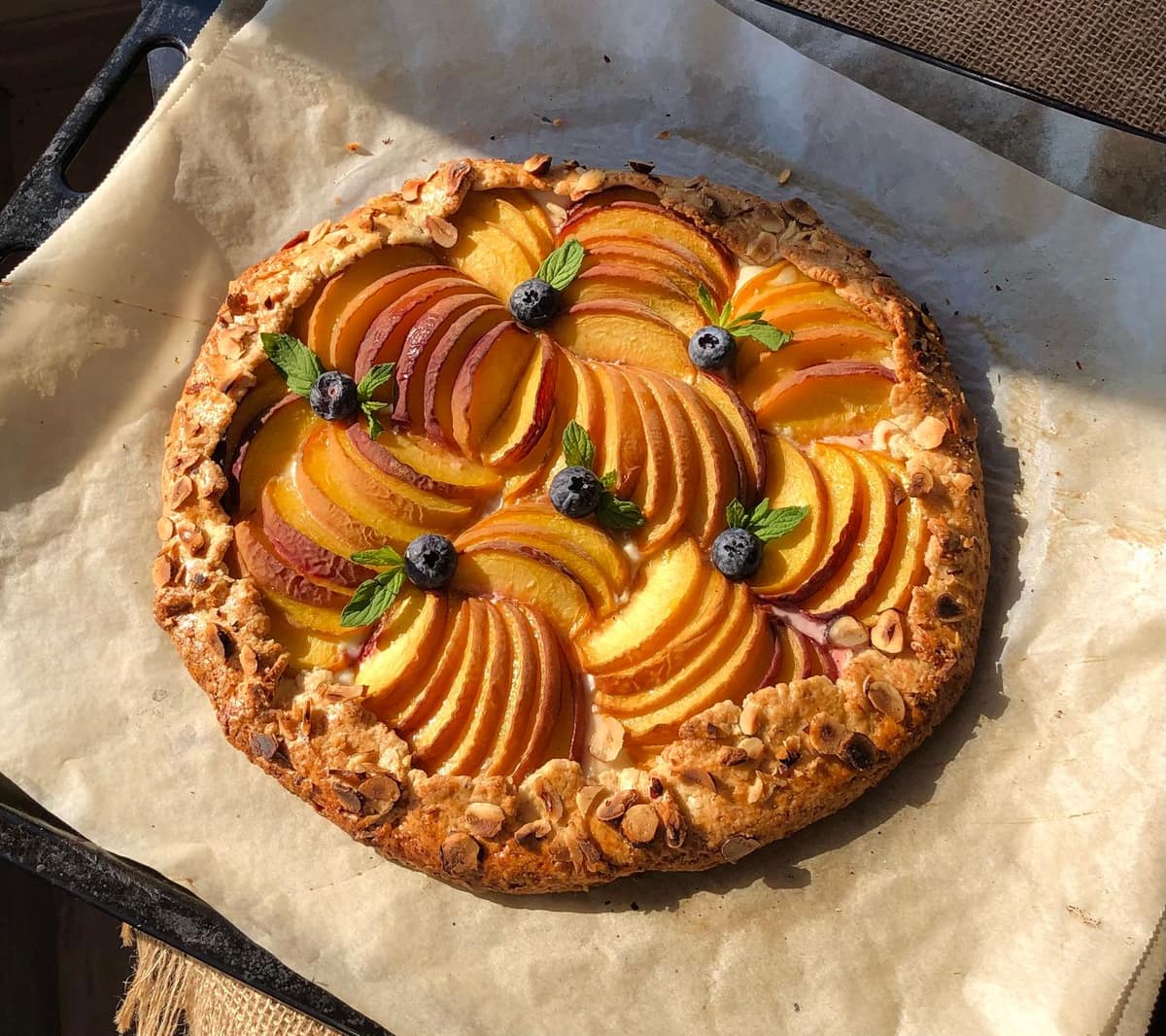 A baked fruit tart with a golden almond frangipane filling