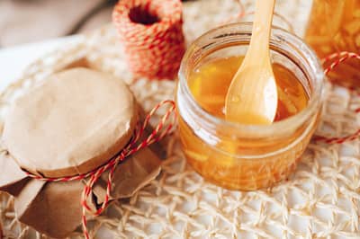 A jar of golden citrus curd with a dripping spoon