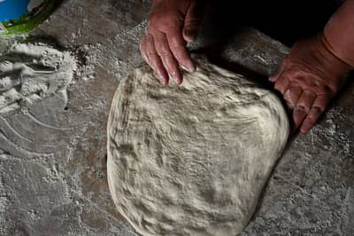 Elastic bread dough being stretched by hand