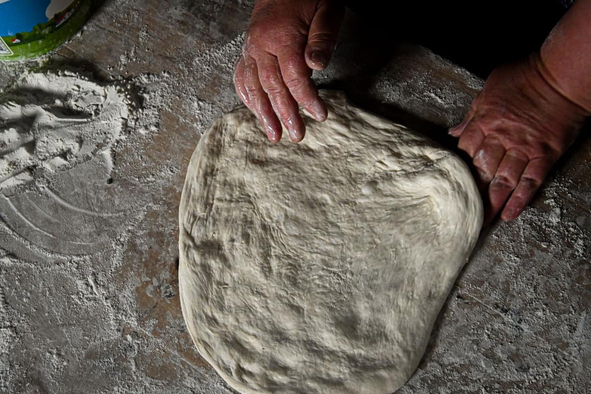 Elastic bread dough being stretched by hand