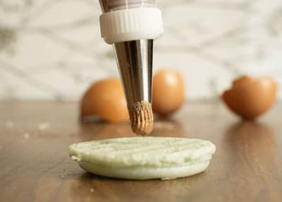 Macaron shells piped from batter after macaronage