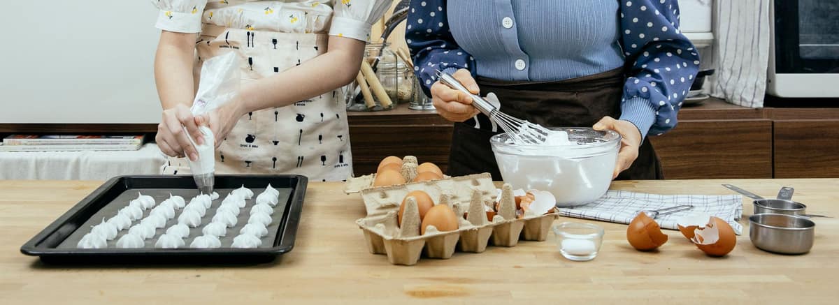 Meringue kisses being piped onto a baking tray
