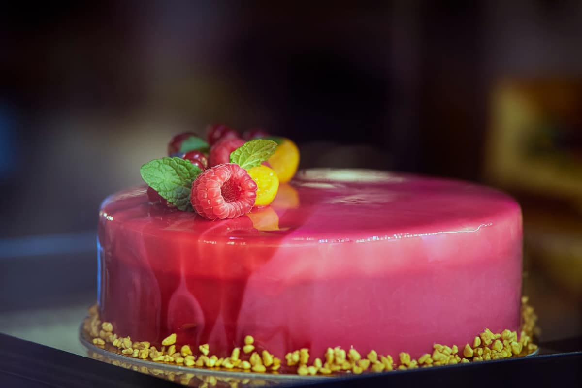 A cake finished in a reflective pink mirror glaze