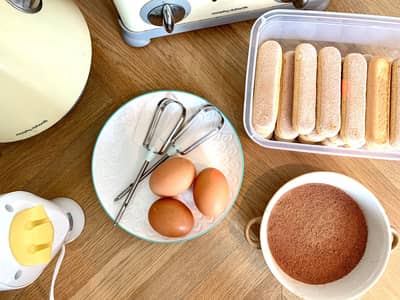 Savoiardi ladyfinger biscuits laid out beside eggs