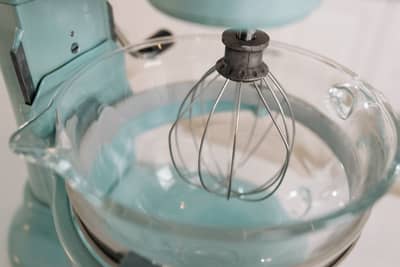 Glossy whipped peaks holding their shape on a whisk