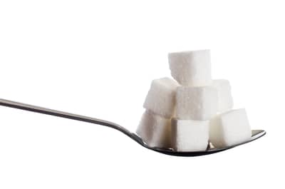A spoonful of alternative sweetener held over a table