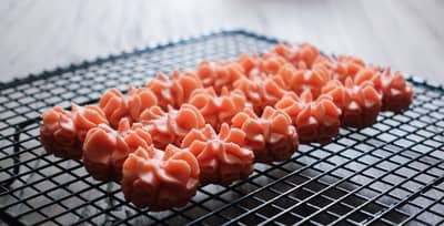 Silky buttercream rosettes piped on a cooling rack
