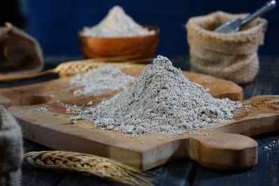 Hands working soft dough in a cloud of wheat flour